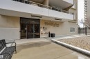 The property features a concrete exterior with a prominent entrance, glass doors, and a decorative sign - 1202 9909 110 Street Nw, Edmonton, AB  -  With Exterior 