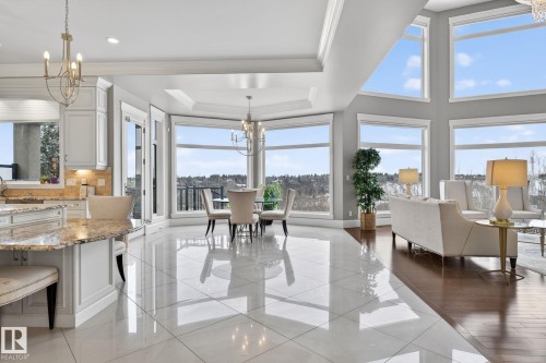This expansive open-concept living space features large windows that offer scenic views, high ceilings with crown molding, and a combination of gleaming tile and hardwood flooring - 1413 Woodward Crescent, Edmonton, AB - Indoor