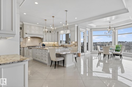 Spacious kitchen and dining area featuring light-colored cabinetry, polished tile flooring, and large windows that provide abundant natural light and expansive views - 1413 Woodward Crescent, Edmonton, AB - Indoor