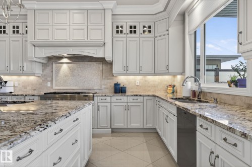 The kitchen features white cabinetry, granite countertops, a tile backsplash, and stainless steel appliances - 1413 Woodward Crescent, Edmonton, AB - Indoor Photo Showing Kitchen With Upgraded Kitchen