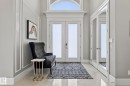 The entrance features a double door with glass panels and an arched transom window above, set against a light-colored wall with decorative molding - 1413 Woodward Crescent, Edmonton, AB  - Indoor Photo Showing Other Room 