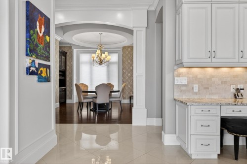 This property features a dining area with a tray ceiling, a decorative chandelier, and hardwood flooring - 1413 Woodward Crescent, Edmonton, AB - Indoor