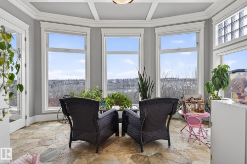 This sunroom features a coffered ceiling, large windows providing expansive views of the distant landscape, and flagstone flooring - 1413 Woodward Crescent, Edmonton, AB - Indoor
