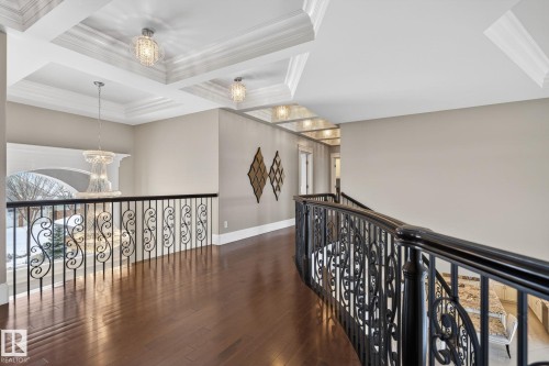 This elegant hallway features rich hardwood flooring and decorative metal railings with ornate scrollwork - 1413 Woodward Crescent, Edmonton, AB - Indoor Photo Showing Other Room