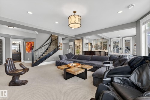 The living area features light-colored carpeting, a staircase with dark wood railings and decorative metalwork, and recessed lighting - 1413 Woodward Crescent, Edmonton, AB - Indoor