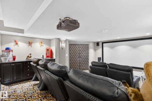 The property features a dedicated media room with a large projection screen, recessed lighting, and a dark wood wet bar with a countertop - 1413 Woodward Crescent, Edmonton, AB - Indoor