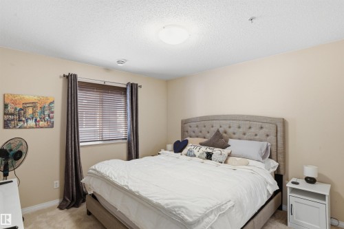 The property features a bedroom with a window dressed with blinds and curtains - 115 6925 199 Street, Edmonton, AB - Indoor Photo Showing Bedroom