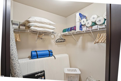Well-organized storage space featuring white wire shelving and hanging rods - 115 6925 199 Street, Edmonton, AB - Indoor With Storage