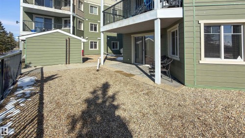 The property features a patio area with a sliding glass door and an adjacent window with blinds - 115 6925 199 Street, Edmonton, AB - Outdoor With Exterior