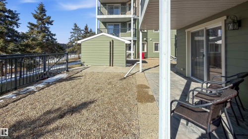 This property features a paved patio area with a sliding glass door entry - 115 6925 199 Street, Edmonton, AB - Outdoor With Exterior