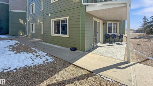 The property features a private patio with a concrete surface, accessible via a sliding glass door - 115 6925 199 Street, Edmonton, AB - Outdoor With Exterior