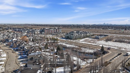 Aerial view of the surrounding area featuring residential properties, roads, and open land - 115 6925 199 Street, Edmonton, AB - Outdoor With View