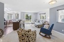 Open concept living area with carpet flooring, light gray walls, and large windows with blinds - 115 6925 199 Street, Edmonton, AB  - Indoor Photo Showing Living Room 