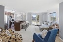Open concept living area with carpeting, a kitchen featuring stainless steel appliances, and a sliding glass door leading to an outdoor space - 115 6925 199 Street, Edmonton, AB  - Indoor 