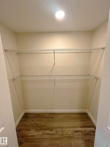 The property features a closet with two wire shelves, a recessed light fixture, and wood-look flooring - 56 Salisbury Avenue, St. Albert, AB - Indoor With Storage