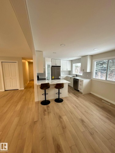 The kitchen features white cabinetry, a light-colored subway tile backsplash, and stainless steel appliances - 56 Salisbury Avenue, St. Albert, AB - Indoor