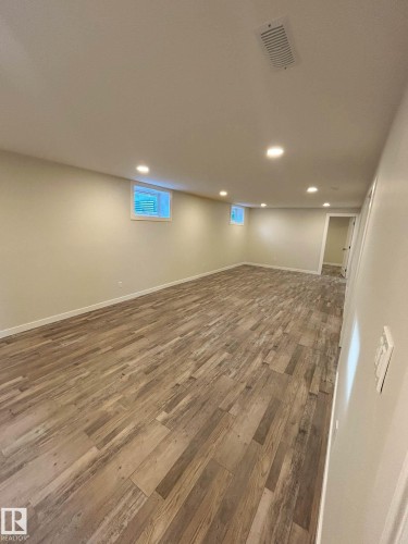 Spacious open-concept room featuring wide plank flooring, recessed lighting, and light-colored walls - 56 Salisbury Avenue, St. Albert, AB - Indoor