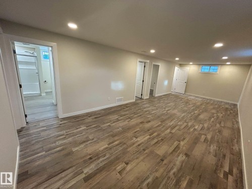 Spacious room featuring wood-look flooring, recessed lighting, and light-colored walls - 56 Salisbury Avenue, St. Albert, AB - Indoor