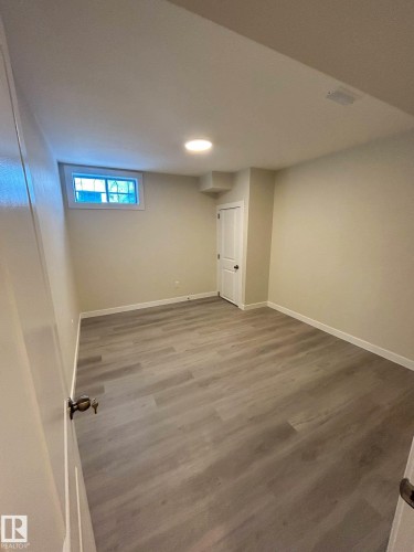 This room features light-colored walls, recessed lighting, and wood-look flooring - 56 Salisbury Avenue, St. Albert, AB - Indoor Photo Showing Basement