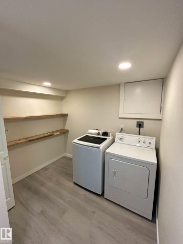 Dedicated laundry area featuring a washer and dryer, light wood-toned shelving, recessed lighting, and light grey flooring - 56 Salisbury Avenue, St. Albert, AB - Indoor Photo Showing Laundry Room