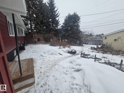 The property features a red exterior, a wooden deck, and a yard with mature trees - 56 Salisbury Avenue, St. Albert, AB - Outdoor