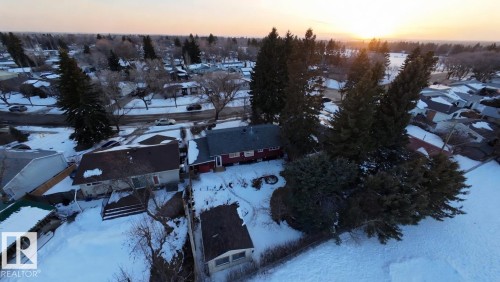 The property features a red facade and a brown roof, situated on a lot with mature trees - 56 Salisbury Avenue, St. Albert, AB - Outdoor With View