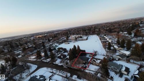 Aerial view of the property, outlined in red, set within a residential area featuring numerous trees and snow-covered grounds - 56 Salisbury Avenue, St. Albert, AB - Outdoor With View