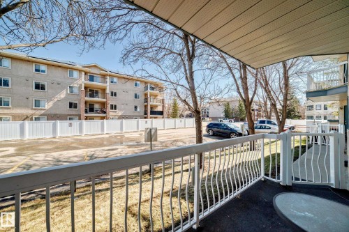 The property features an outdoor patio with a white railing and a view of the surrounding exterior - 112 17150 94A Avenue, Edmonton, AB - Outdoor