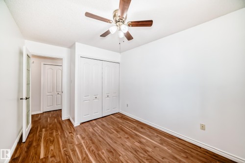The room features wood flooring, white walls, and a ceiling fan - 112 17150 94A Avenue, Edmonton, AB - Indoor Photo Showing Other Room