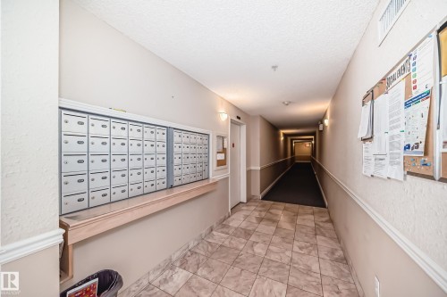 The building features a hallway with tiled flooring, wall-mounted mailboxes, and bulletin boards - 112 17150 94A Avenue, Edmonton, AB - Indoor Photo Showing Other Room
