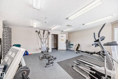 The property includes a fitness room equipped with various exercise machines, including an elliptical, a treadmill, and a rowing machine - 112 17150 94A Avenue, Edmonton, AB - Indoor Photo Showing Gym Room
