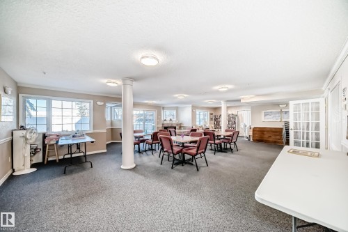 Spacious common area featuring carpeting, multiple windows, recessed lighting, and support columns - 112 17150 94A Avenue, Edmonton, AB - Indoor
