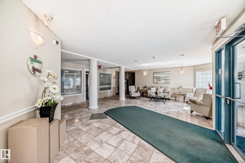 Welcoming lobby area featuring tiled flooring, recessed lighting, and a comfortable seating arrangement - 112 17150 94A Avenue, Edmonton, AB - Indoor Photo Showing Other Room