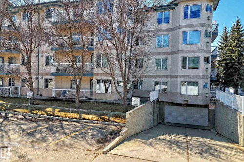 The property features a multi-story building with a light-colored facade and numerous windows - 112 17150 94A Avenue, Edmonton, AB - Outdoor With Facade