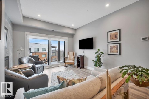 PATIO DOORS FROM YOUR LIVING ROOM LEADING TO YOUR PATIO AND STUNNING RAVINE AND DOWNTOWN VIEWS - 404 7463 May Common Nw, Edmonton, AB - Indoor Photo Showing Living Room