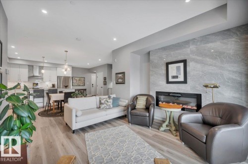 ELECTRIC FIREPLACE WITH TILE SURROUND AND RECESSED BOX FOR TV MOUNTING - 404 7463 May Common Nw, Edmonton, AB - Indoor Photo Showing Living Room With Fireplace