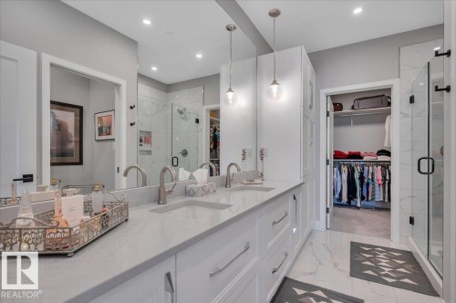 PRIMARY ENSUITE WITH DUAL SINKS AND GRANITE COUNTERS LEADING TO THE LARGE WALK IN CLOSET - 404 7463 May Common Nw, Edmonton, AB - Indoor Photo Showing Bathroom