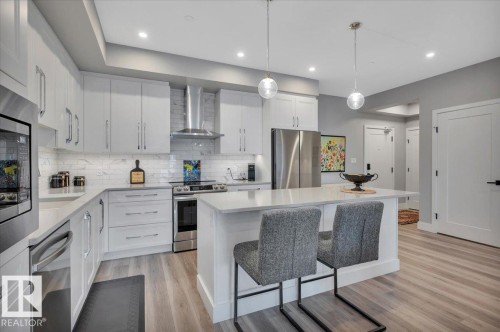QUARTZ COUNTERS, LARGE ISLAND AND UNDER COUNTER LIGHTING - 404 7463 May Common Nw, Edmonton, AB - Indoor Photo Showing Kitchen With Stainless Steel Kitchen With Upgraded Kitchen