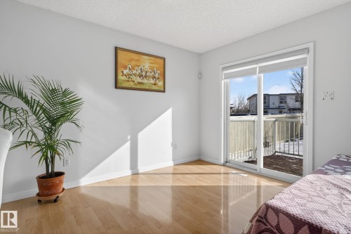 Room featuring wood flooring and a sliding glass door that opens to a balcony - 421 84 Street, Edmonton, AB - Indoor Photo Showing Bedroom