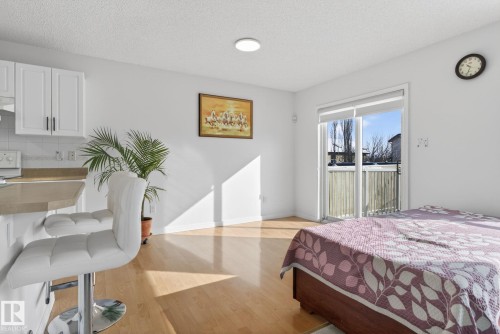 Open concept living space featuring light hardwood flooring, white walls, and a sliding glass door providing access to an outdoor area - 421 84 Street, Edmonton, AB - Indoor Photo Showing Bedroom
