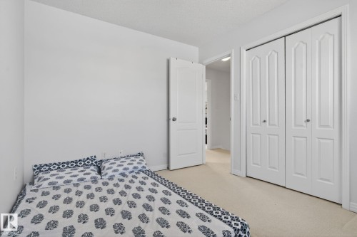 Well-lit room featuring neutral-toned walls, carpeted flooring, and a double bi-fold closet - 421 84 Street, Edmonton, AB - Indoor Photo Showing Bedroom