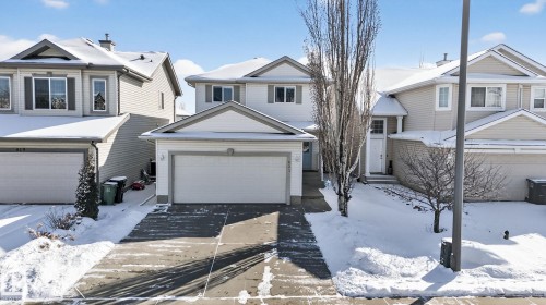 The property features a two-story exterior with a front-facing attached garage and a paved driveway - 421 84 Street, Edmonton, AB - Outdoor With Facade