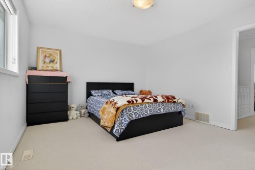 The property features a room with light-colored carpeting and white walls, offering a bright and neutral palette - 421 84 Street, Edmonton, AB - Indoor Photo Showing Bedroom