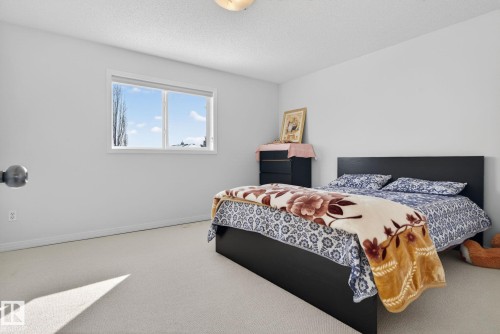The property features a bright room with light-colored carpeting and white walls - 421 84 Street, Edmonton, AB - Indoor Photo Showing Bedroom