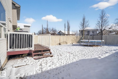 The property includes a wooden deck with white railings, a fenced yard, and a house exterior with light-colored siding - 421 84 Street, Edmonton, AB - Outdoor