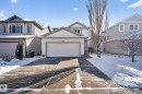 The property features a two-story home with light-colored siding, a front-facing attached garage, and a concrete driveway - 421 84 Street, Edmonton, AB  - Outdoor With Facade 