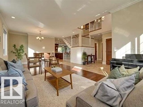 The property features an open-concept living space with hardwood flooring, high ceilings with recessed lighting, and a dining area with a chandelier - 10836 130 Street, Edmonton, AB - Indoor Photo Showing Living Room