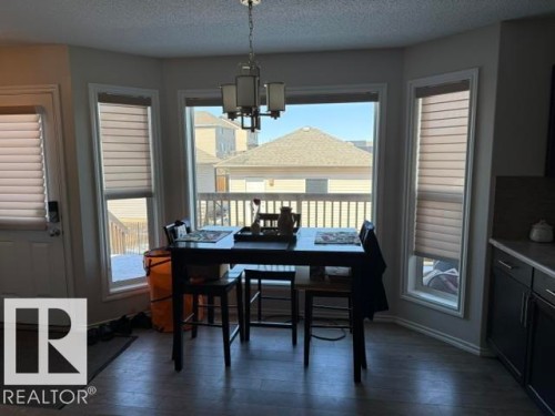 This dining area features a bay window design with three windows, offering natural light and views of the exterior deck and neighborhood - 21316 95 Avenue, Edmonton, AB - Indoor Photo Showing Dining Room