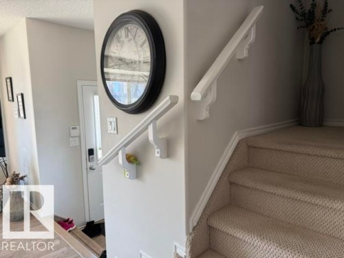 Interior hallway with light gray walls, a white door, and a white handrail - 21316 95 Avenue, Edmonton, AB - Indoor Photo Showing Other Room