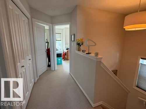 Hallway with light-colored carpet flooring and white bi-fold closet doors - 21316 95 Avenue, Edmonton, AB - Indoor Photo Showing Other Room